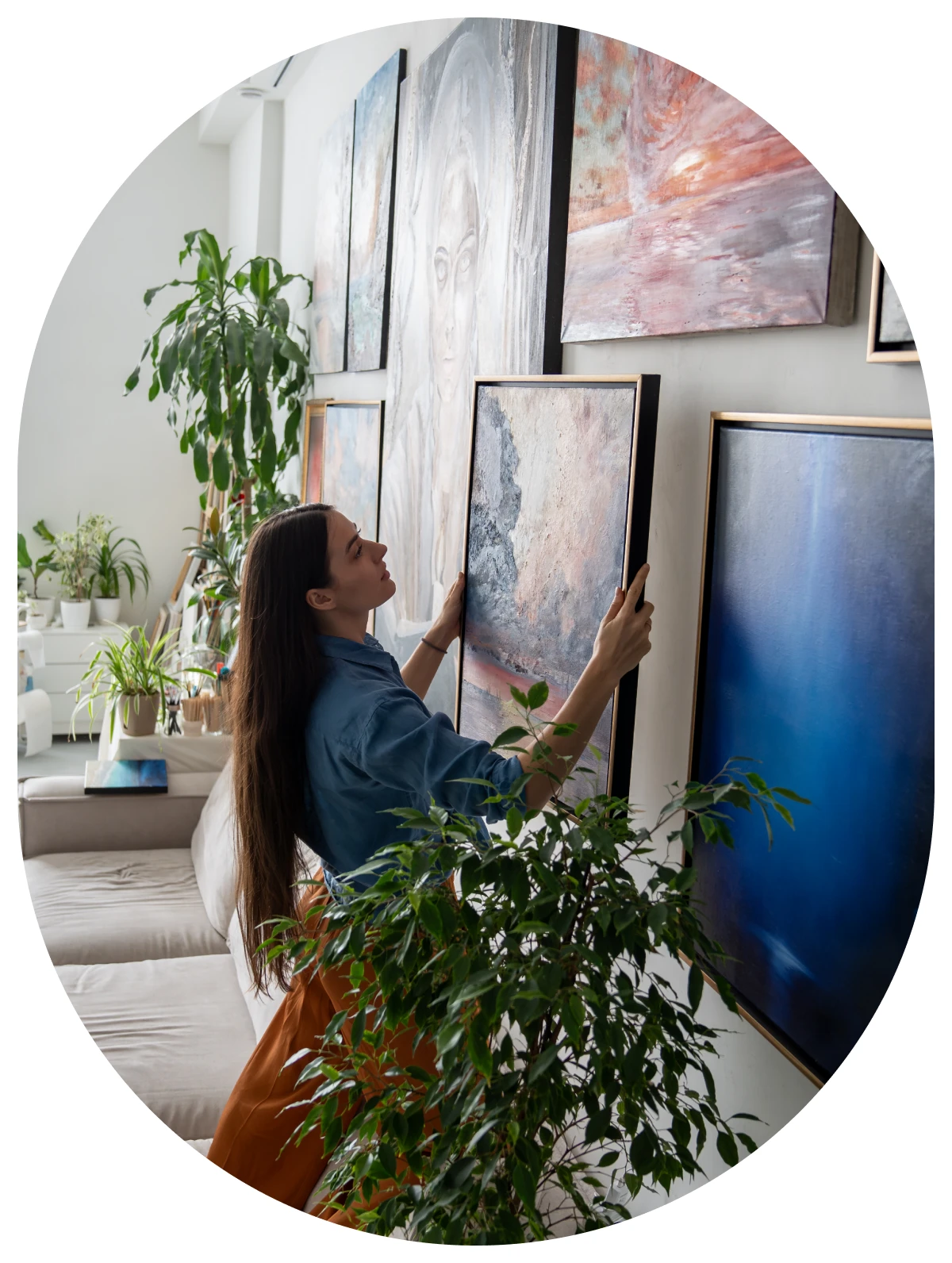 Woman arranging paintings on a wall